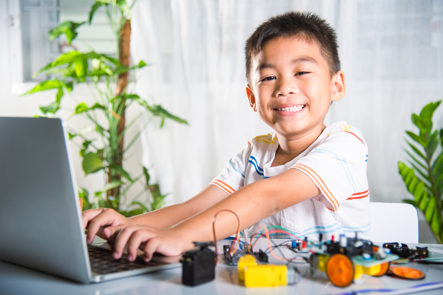Asian kid boy learns coding and programming with laptop for